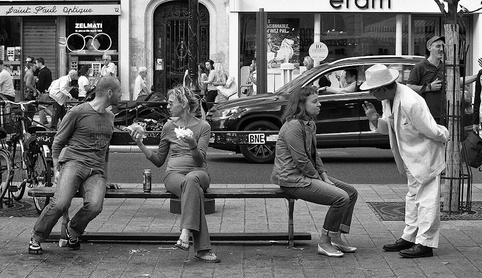 Two pairs of people talking intensely to each other on public sidewalk