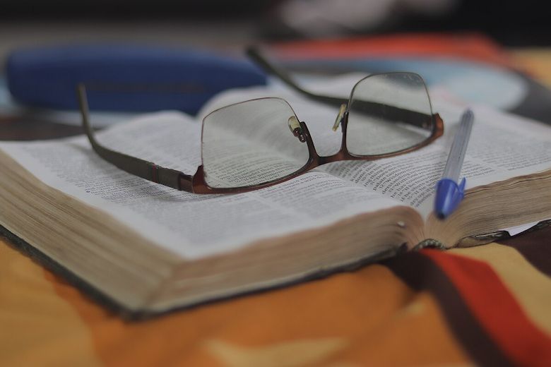 Open Bible with a pair of eyeglasses on it