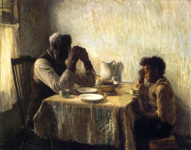 Man and boy bowed in payer over a table with virtually no food on it