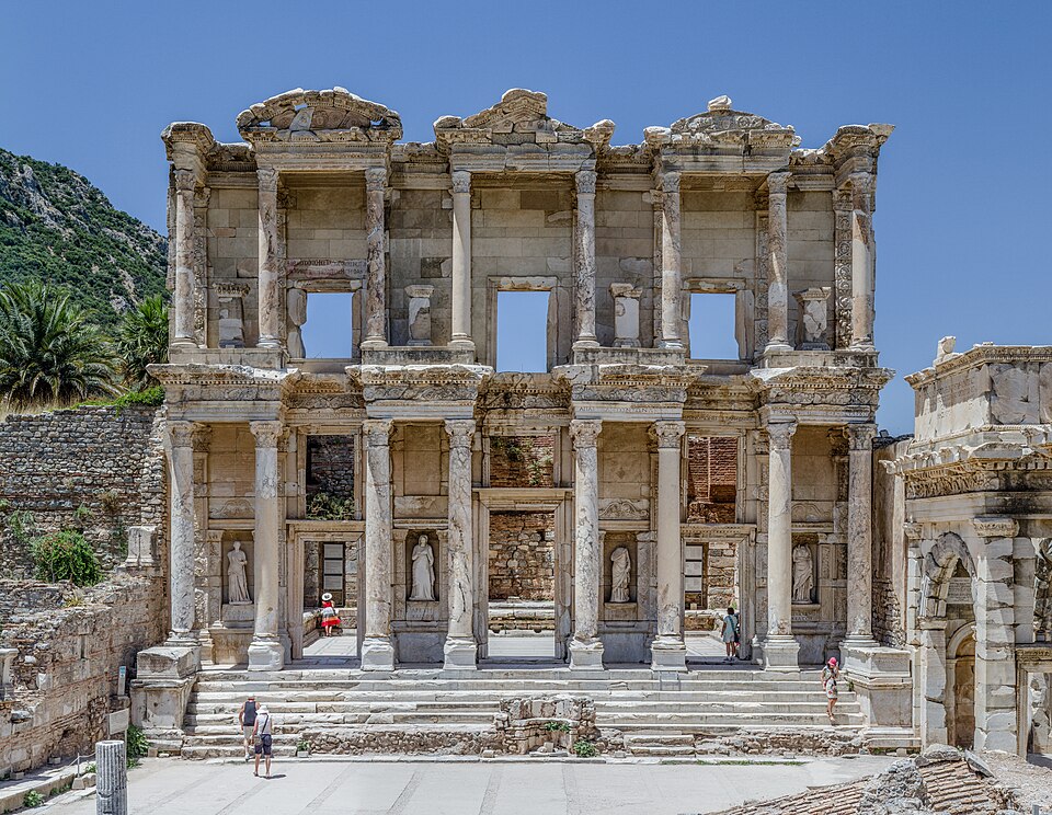 front of a two-story ancient stone building with windows and doors