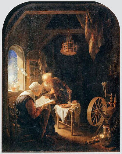 man listening to a woman read the Bible as they sit at home