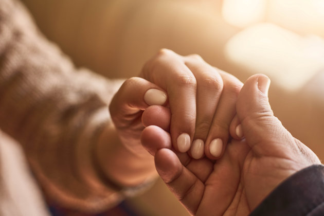One hand grasping another person's hand