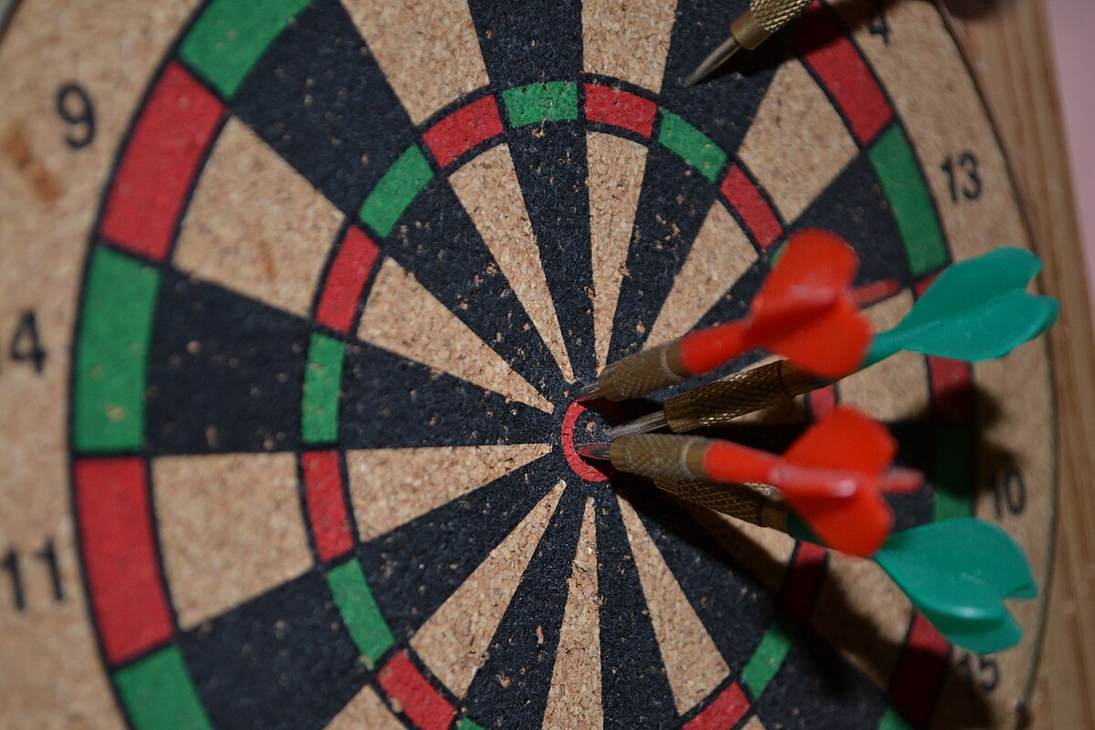 dartboard with darts stuck in the middle