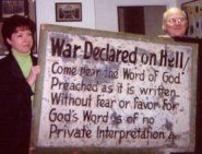photo of two people holding old sign that says, War declared on hell.